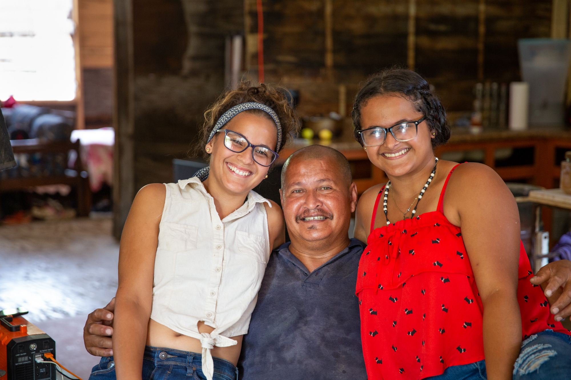 Roberto Cornier and family - Roberto Cornier had 11 strokes in 2017 and was evicted from his home in Peñuelas, Puerto Rico, after Hurricane Maria. His daughters Kenaisha, 21 (left), and Gabriela, 15, took him to the hospital and found a new place for the family to stay – a derelict, abandoned school. (Ellen O'Brien/News21)