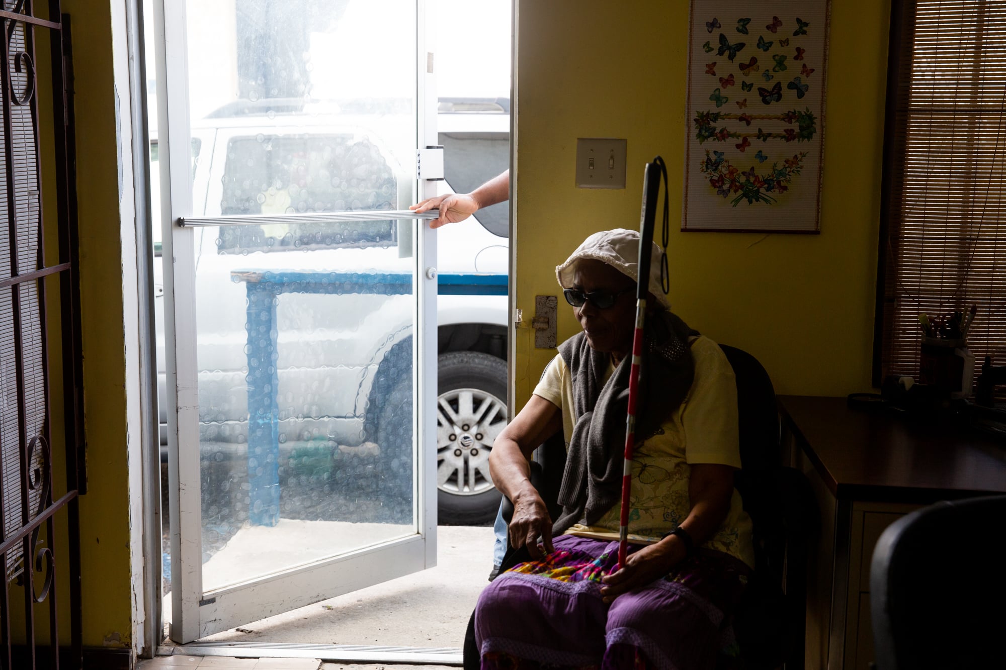 Mable Powell, who is blind, waits for a paratransit bus to pick her up after a meeting of the Virgin Islands Association for Independent Living. Virgin Islands Transit, run by the territorial government, provides transportation to people who can't drive themselves. (Anya Magnuson/News21)