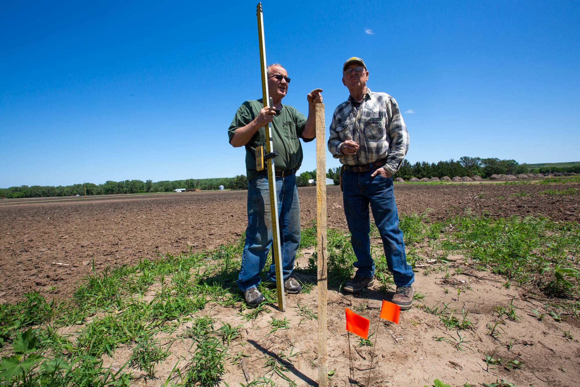 Dan Vakoc (left) plots dimensions for a repair shop on Willard Ruzicka's farm in northeastern Nebraska. Ruzicka (right) lost about 25 buildings in the flooding in March. The Ruzickas have been on their land  since the Homestead Act of 1862. (Anya Magnuson/News21)