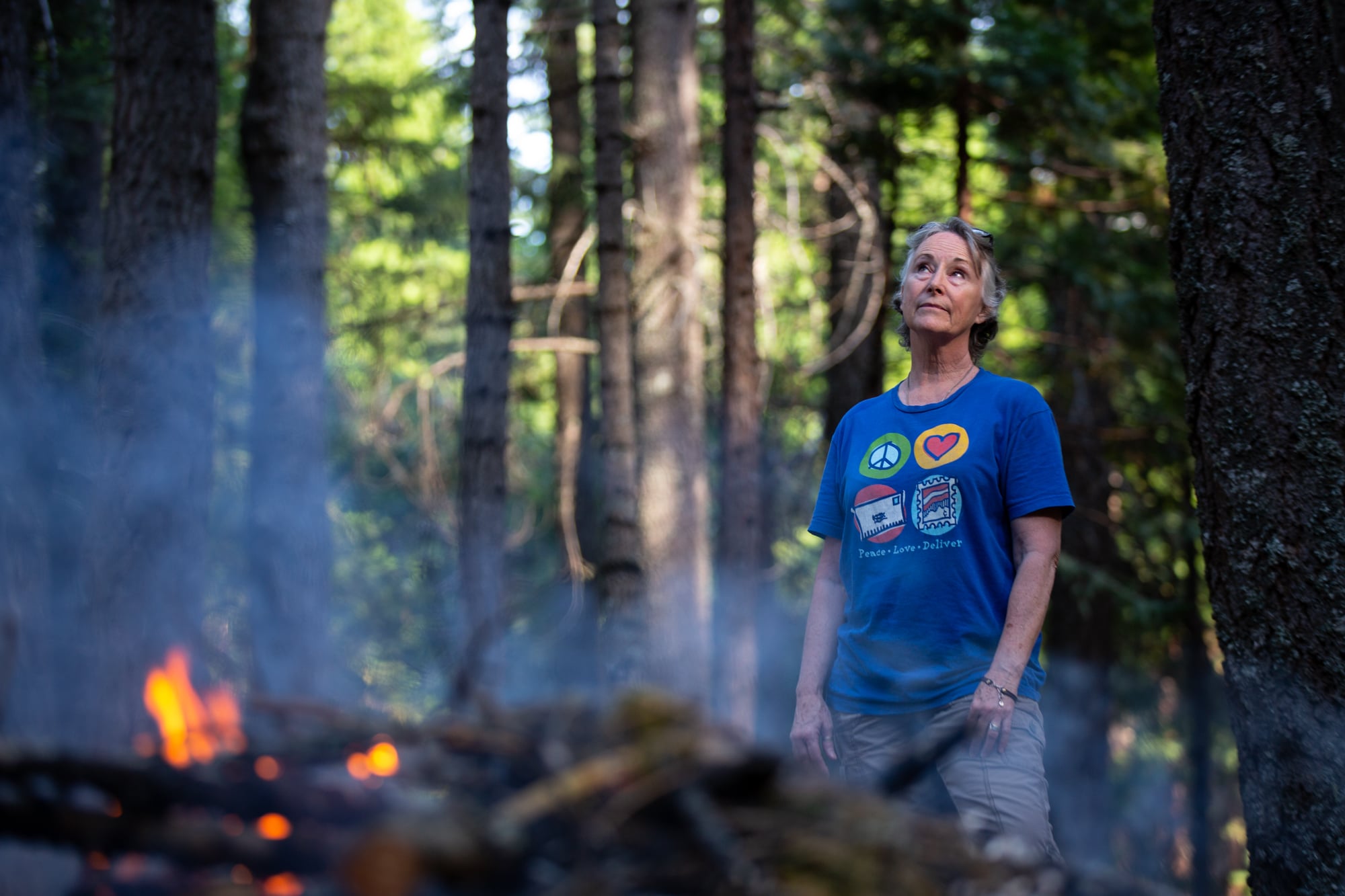Kelly Loew is creating a defensible space around her home in Shingletown, California, by trimming pine branches and burning them in a pile. It’s a common but dangerous practice in the forested community. (Anton L. Delgado/News21)