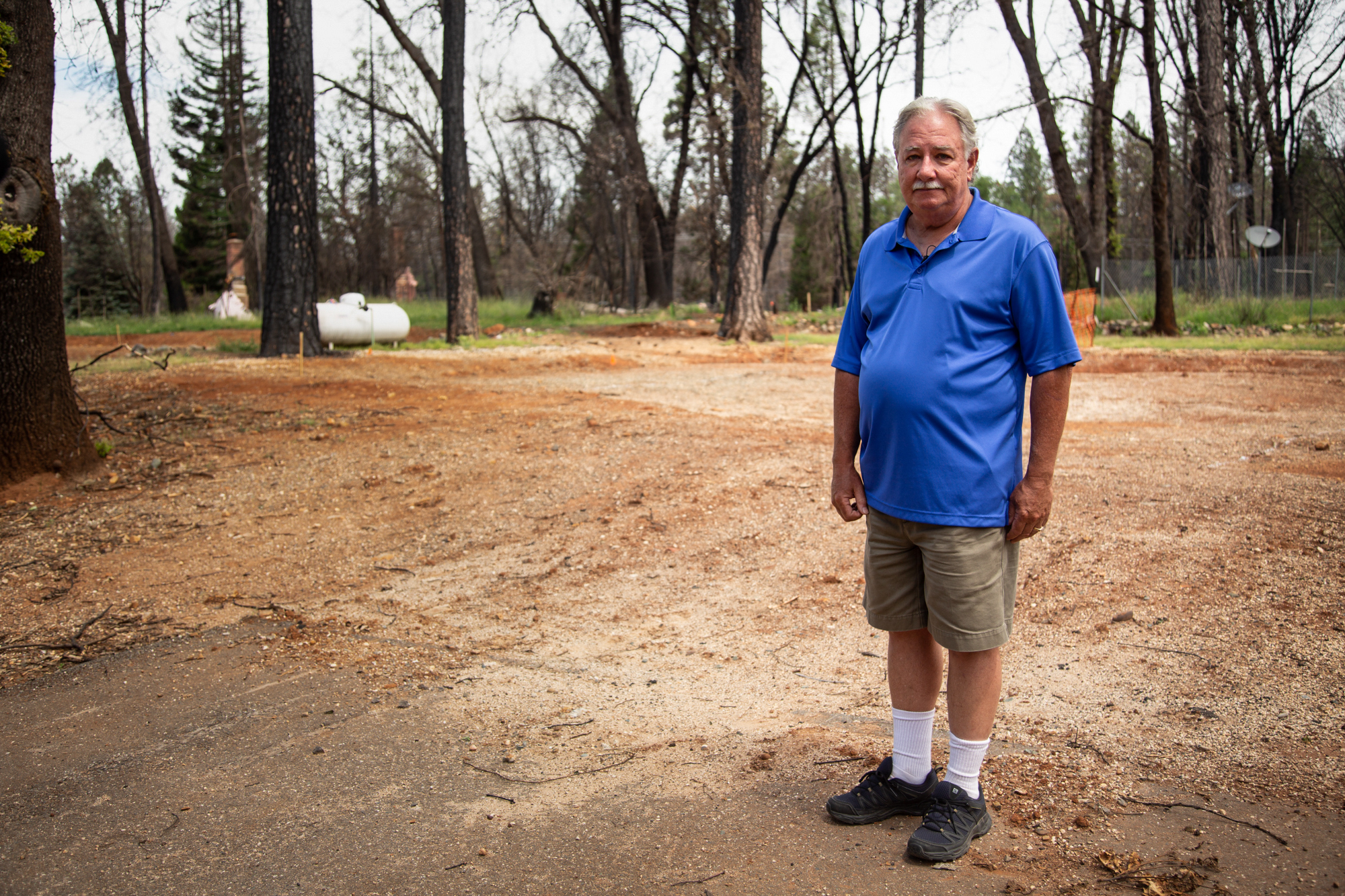 Scott Martin - Scott Martin stands on the edge of the lot where his daughter's house used to stand in Magalia, California. Her house burned to the ground in the Camp Fire, and Martin went through the rubble that was left over, finding the body of one of his daughter's cats. (Allie Barton/News21)