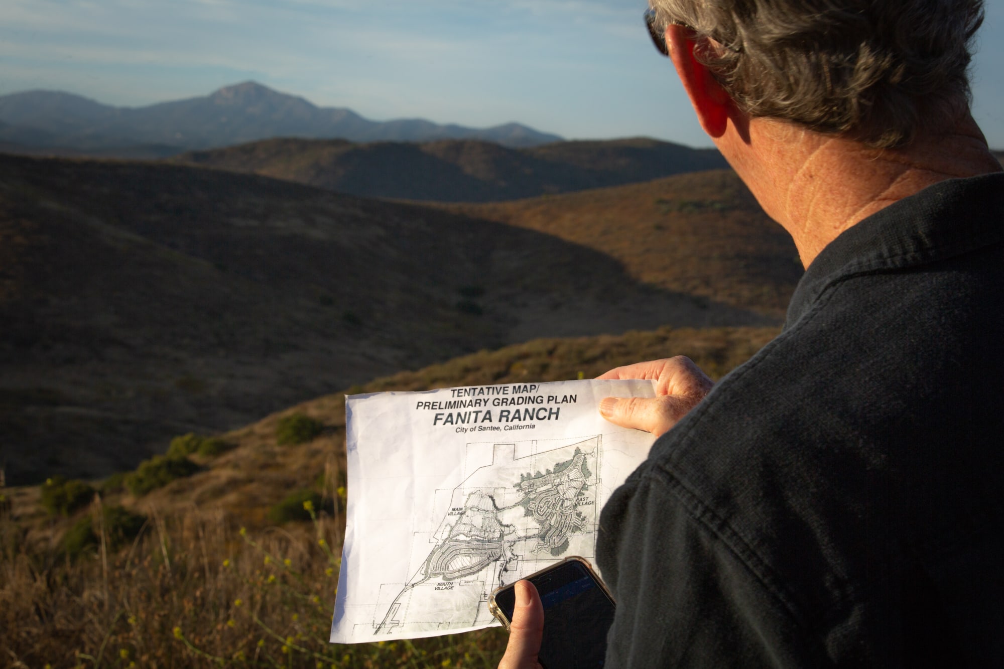Van Collinsworth, a former firefighter with the U.S. Forest Service, checks the proposed layout of Fanita Ranch, a development in Santee, California. Fanita Ranch had gone back and forth between planning and legal battles for about a decade. It initially was approved in 2007, but its environmental impact reports were declared inadequate in 2013.  (Kailey Broussard/News21)